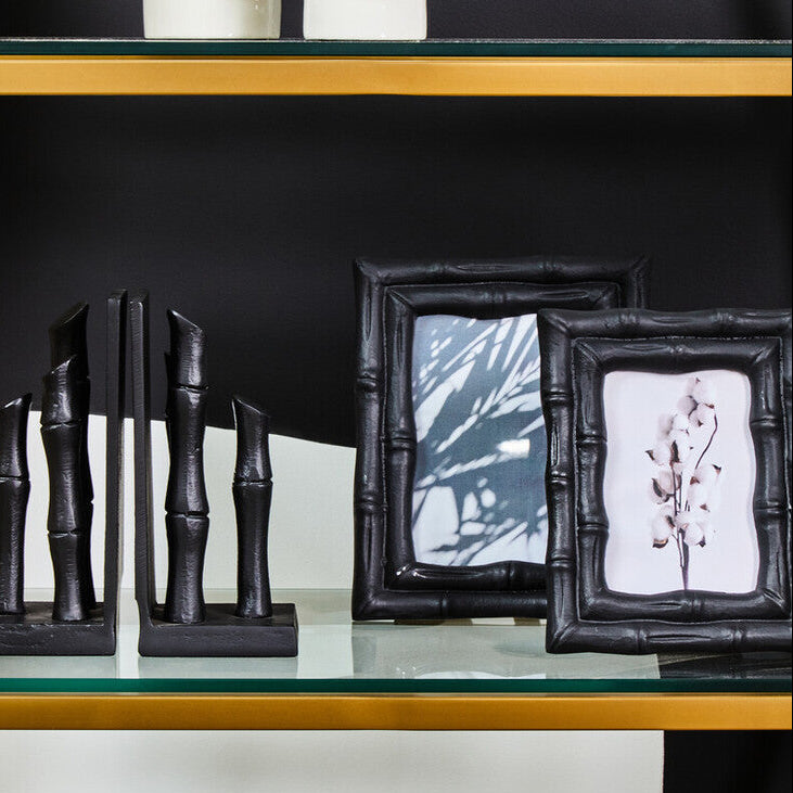 Decorative items including black bamboo sculptures and picture frames on a glass shelf.