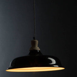 Black pendant light against a dark background