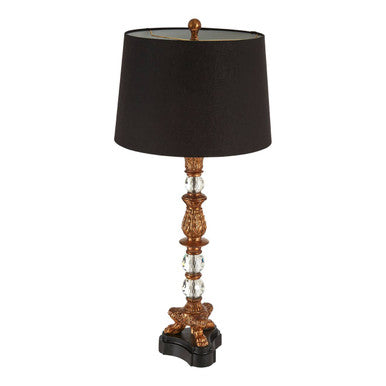 Decorative table lamp with a black shade and ornate gold base on a white background