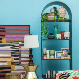 Decorative room with colorful furniture and decor against a blue wall.