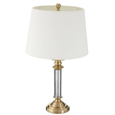 Table lamp with white shade and brass base on a white background