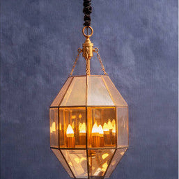 Decorative pendant light with geometric glass shade on a dark blue background