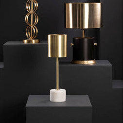 Three table lamps with gold and black designs on a dark background