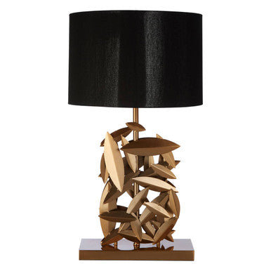 Table lamp with a black shade and gold abstract base on a white background