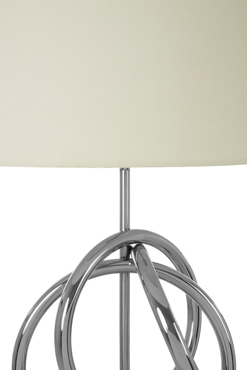 Close-up of a lamp with a metallic base and white shade on a light background