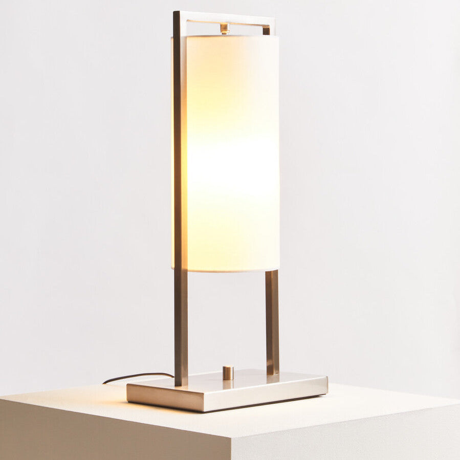 Modern table lamp with a white shade on a light surface with a white background