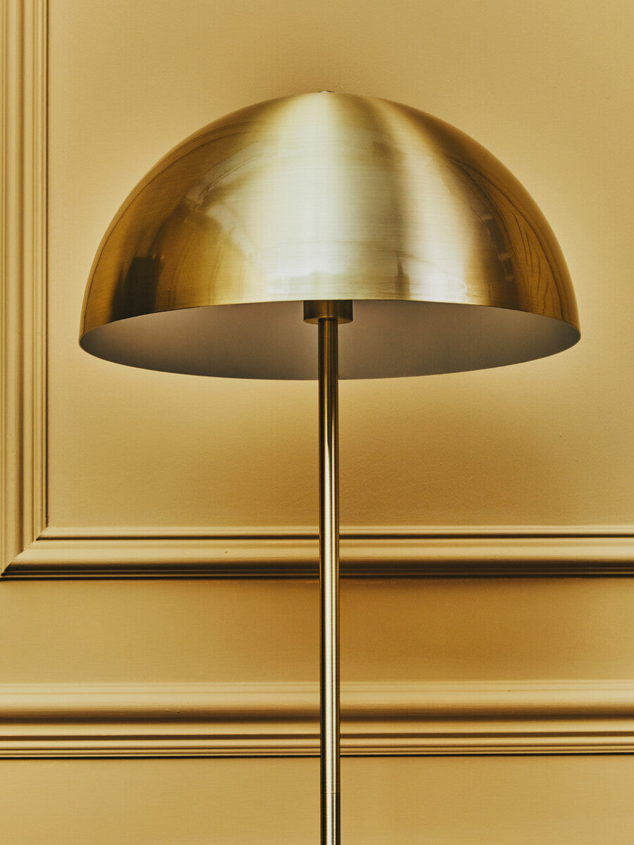 Gold dome-shaped lamp against a gold wall