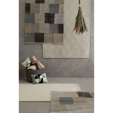 Rugs with geometric patterns on a wall and floor in a room setting.