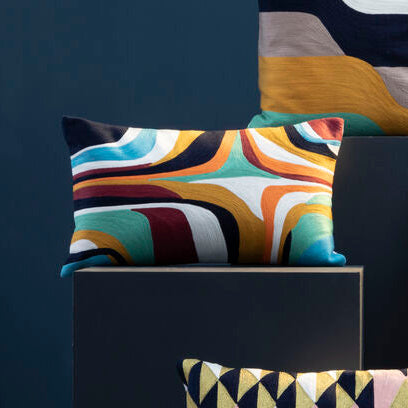Colorful geometric-patterned pillows on a dark background