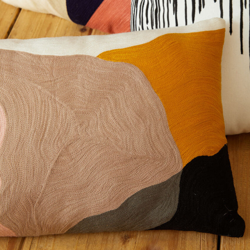 Colorful pillows with abstract patterns on a wooden surface