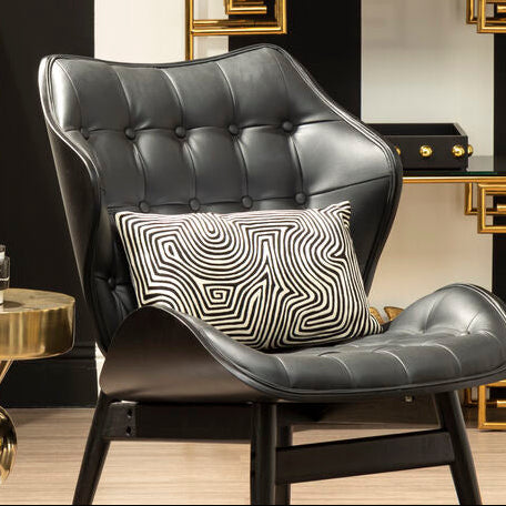 Modern interior design with a black armchair, gold side table, and decorative wall shelf.
