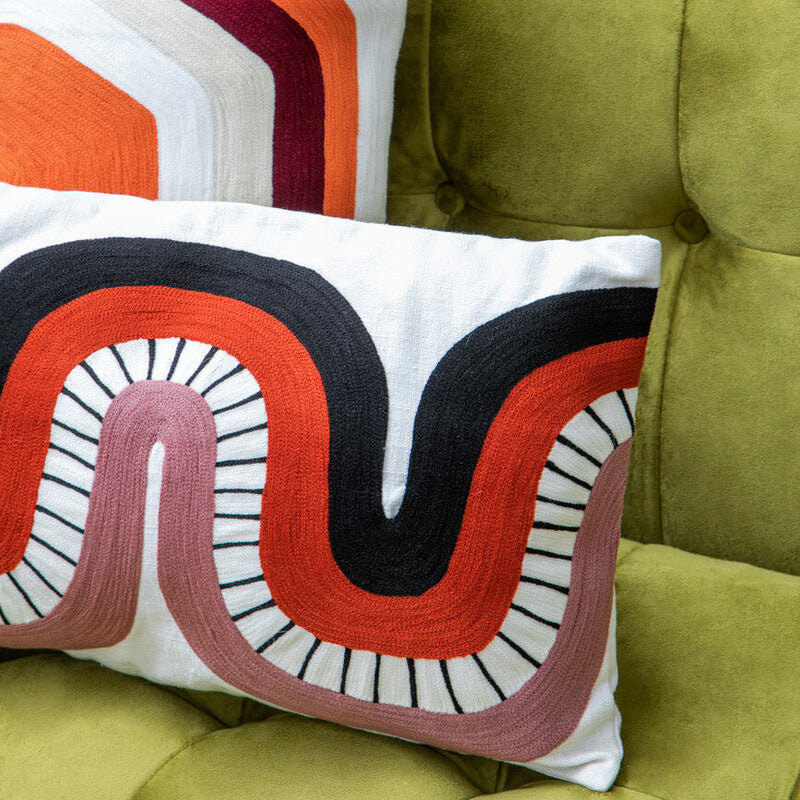 Decorative pillows with geometric patterns on a green sofa