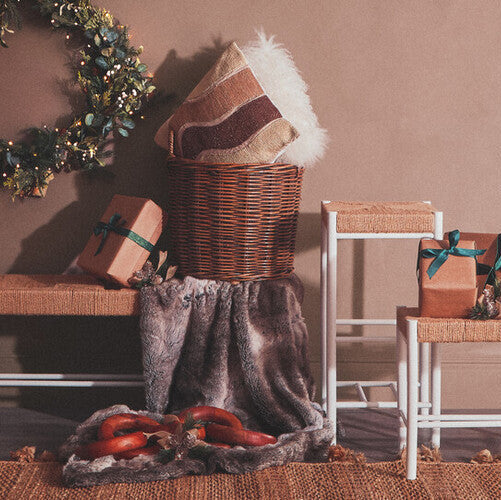 Decorative setup with a wreath, baskets, and gift boxes on a wooden floor.