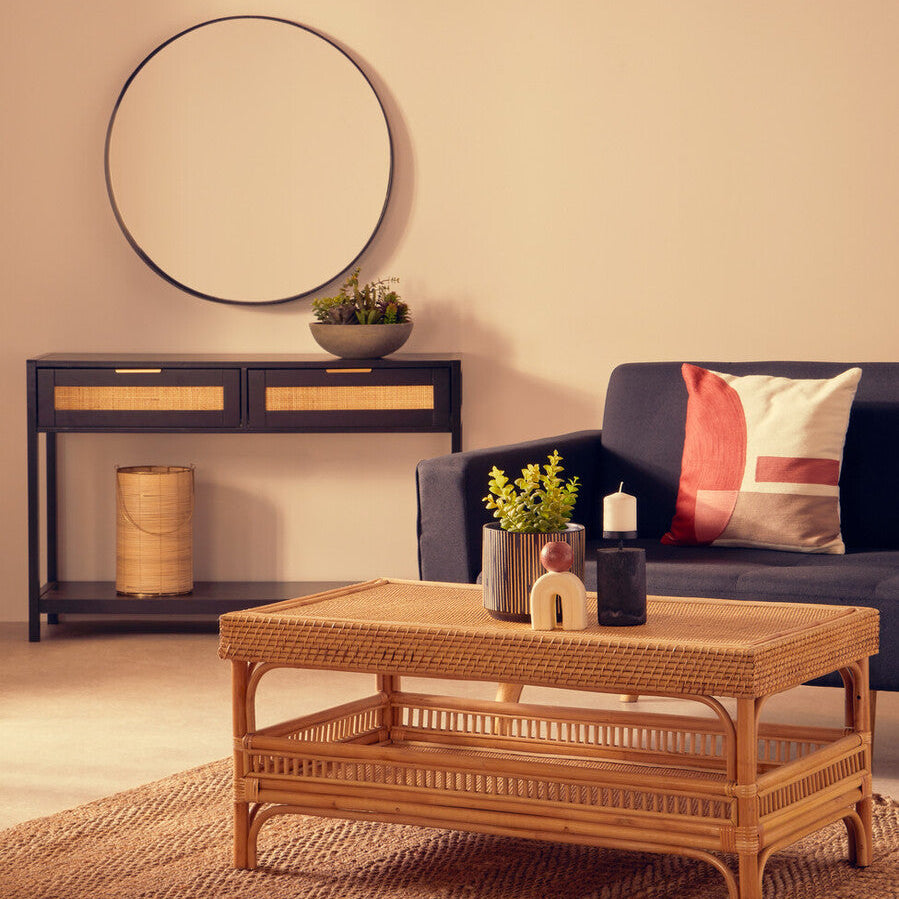 Living room with a wicker coffee table, blue sofa, and decorative items.