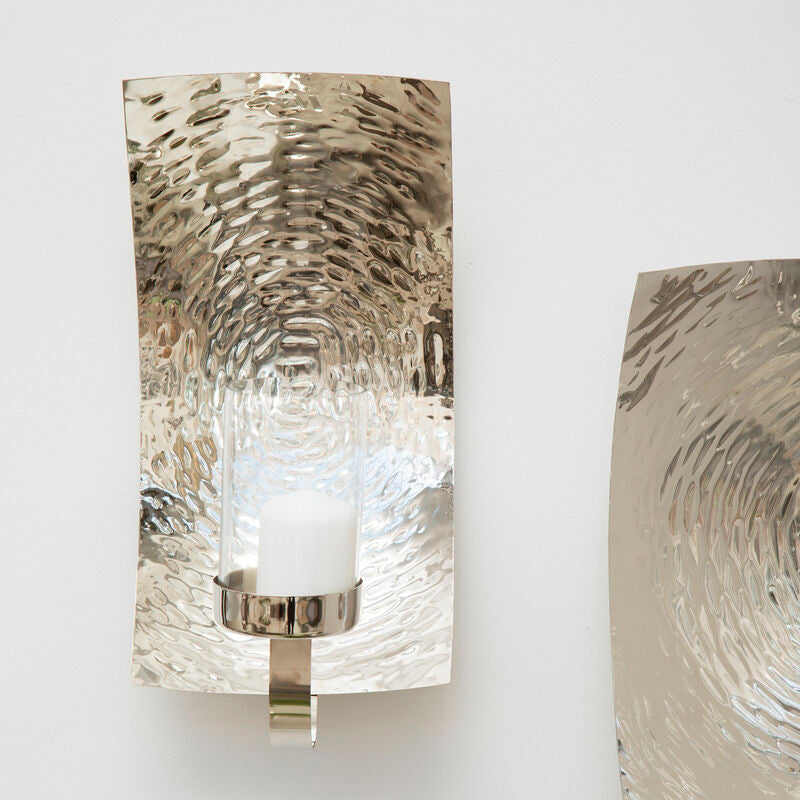 Two wall sconces with textured glass shades on a white wall.