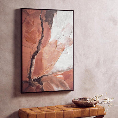 Abstract art piece on a wall above a brown leather bench.