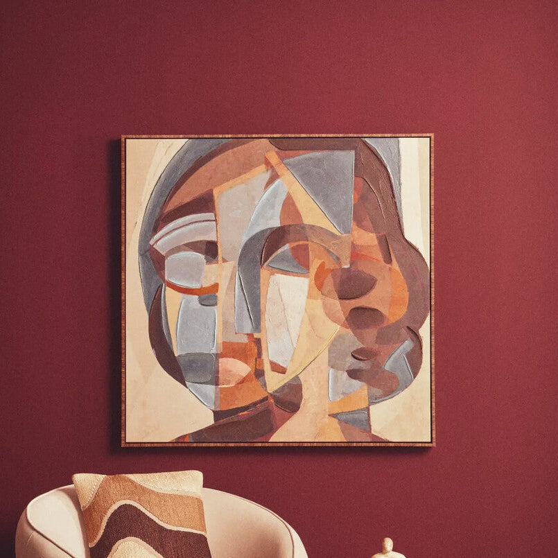 Modern living room with a beige armchair, abstract painting, and side table.