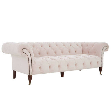 Pink tufted sofa with wooden legs on a white background
