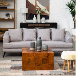 Modern living room with a gray sofa, wooden coffee table, and abstract art on the wall.