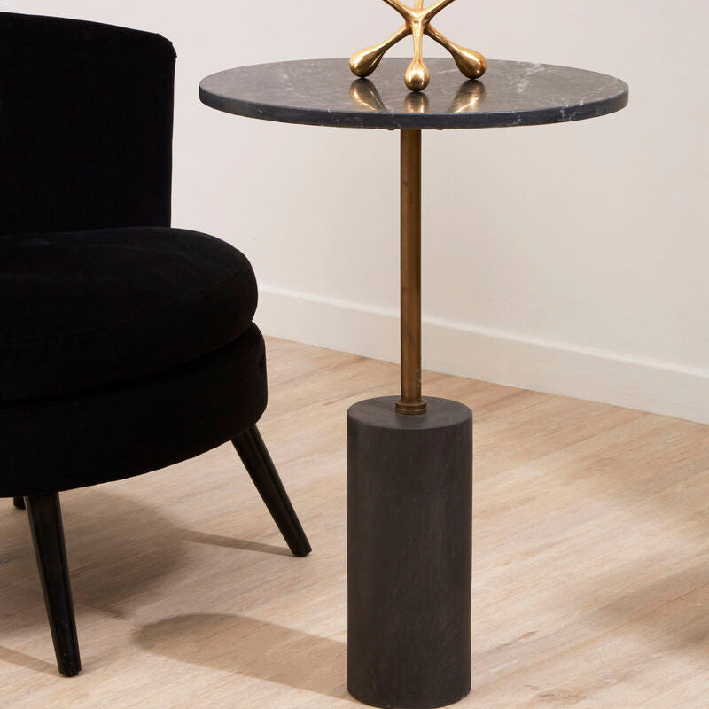 Small round side table with marble top and black cylindrical base, featuring a decorative gold sculpture.
