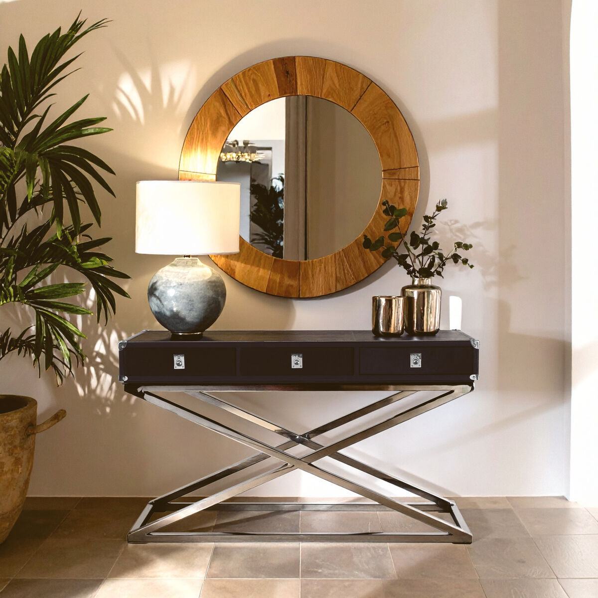 Modern interior design with a round wooden mirror, black console table, and decorative items.