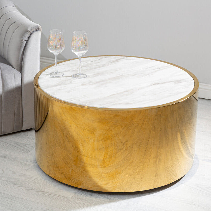 Round wooden coffee table with marble top in a living room setting.