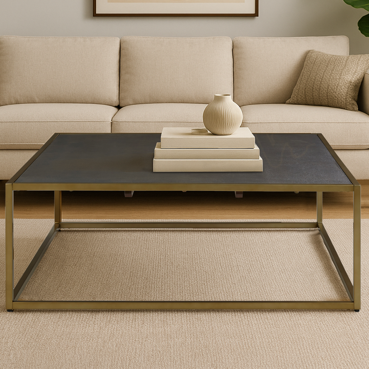 Beige sofa with a coffee table featuring a vase and books in a living room setting.