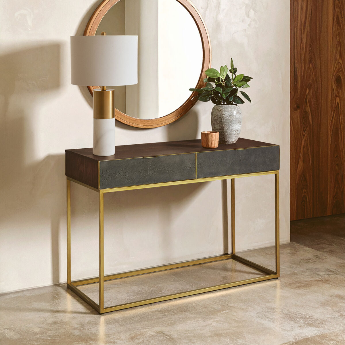 Console table with gold frame and black top in a room setting