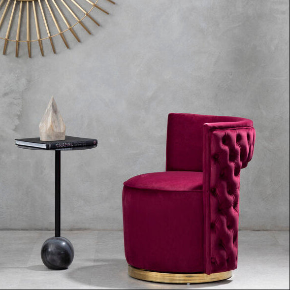 Modern interior with a gold-framed mirror and a pink chair against a gray wall.