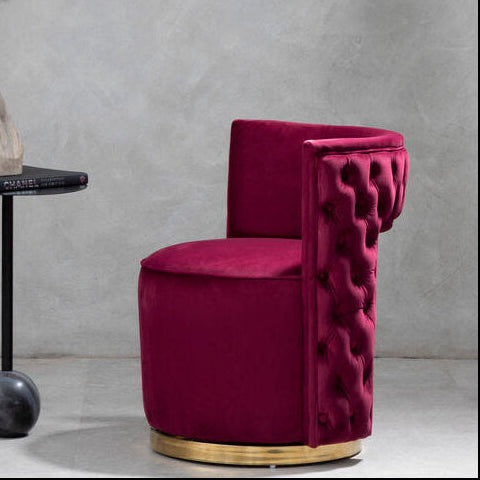 Modern interior with a gold-framed mirror and a pink chair against a gray wall.