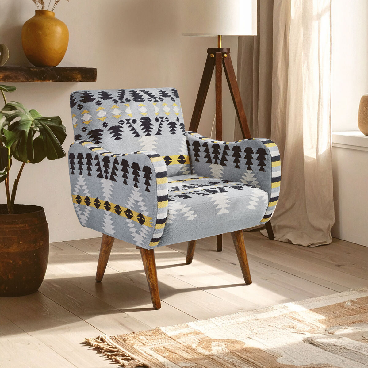 Patterned armchair in a room with a plant and lamp