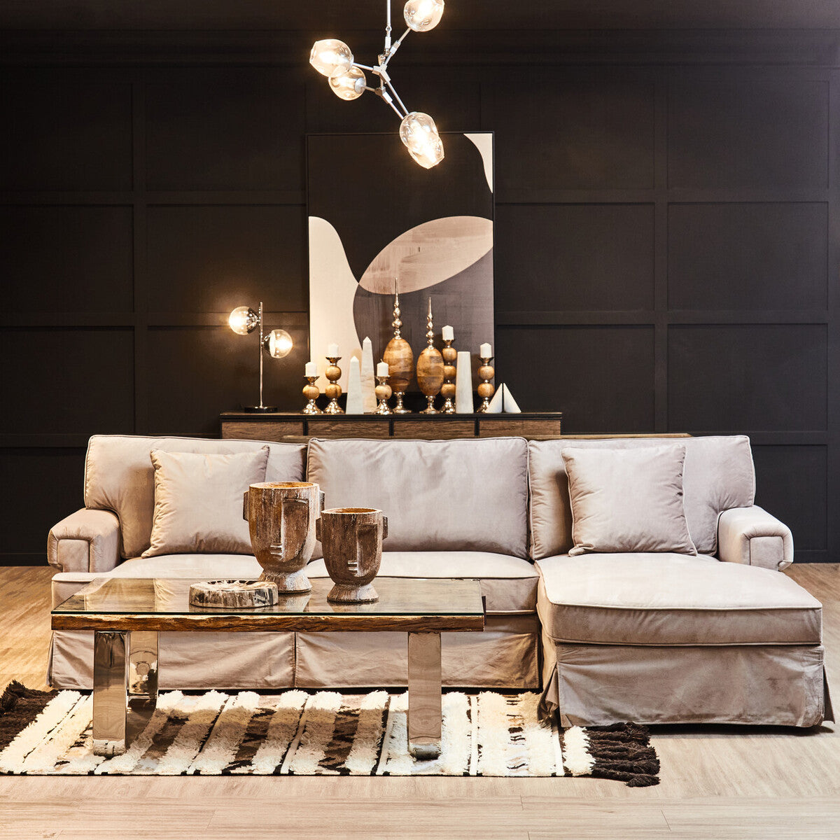 Modern living room with a gray sectional sofa, coffee table, and decorative items.
