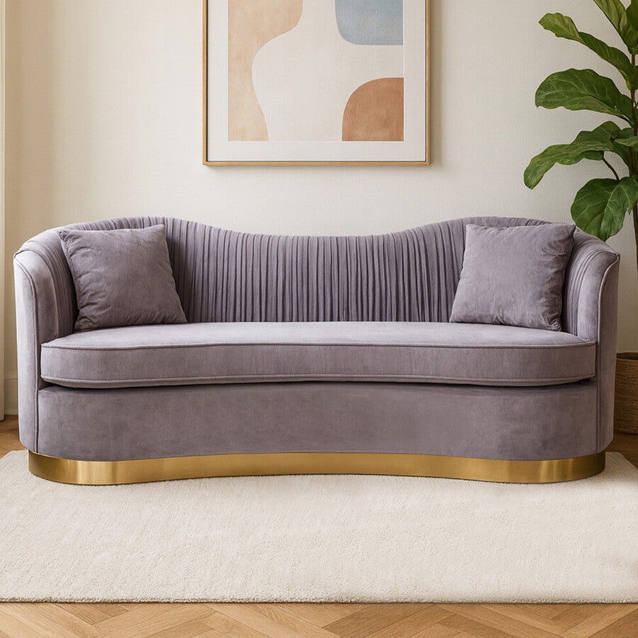 Purple sofa with gold base in a room with abstract art and plant