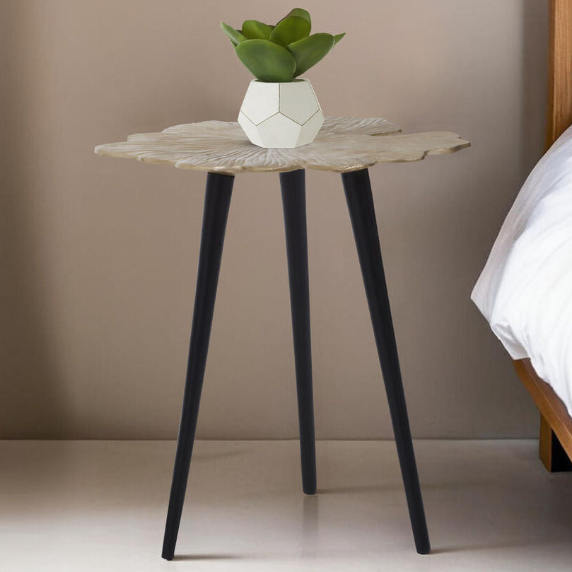 Small side table with a plant next to a bed in a bedroom setting