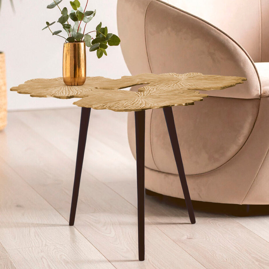 Modern beige armchair with a decorative side table and plant in a living room setting.