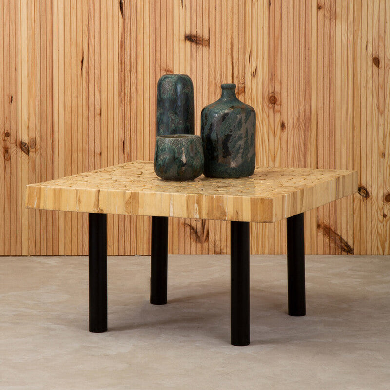 Wooden table with black legs against a wooden wall