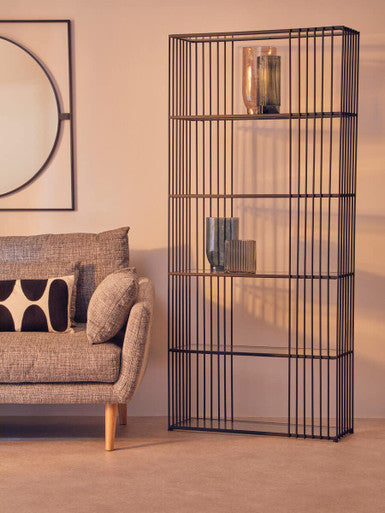 Black metal shelving unit in a living room with a sofa and decorative pillows.