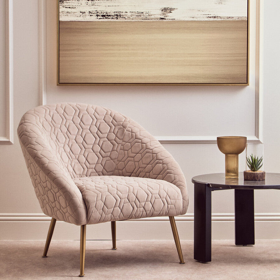 Beige armchair in a room with abstract art on the wall