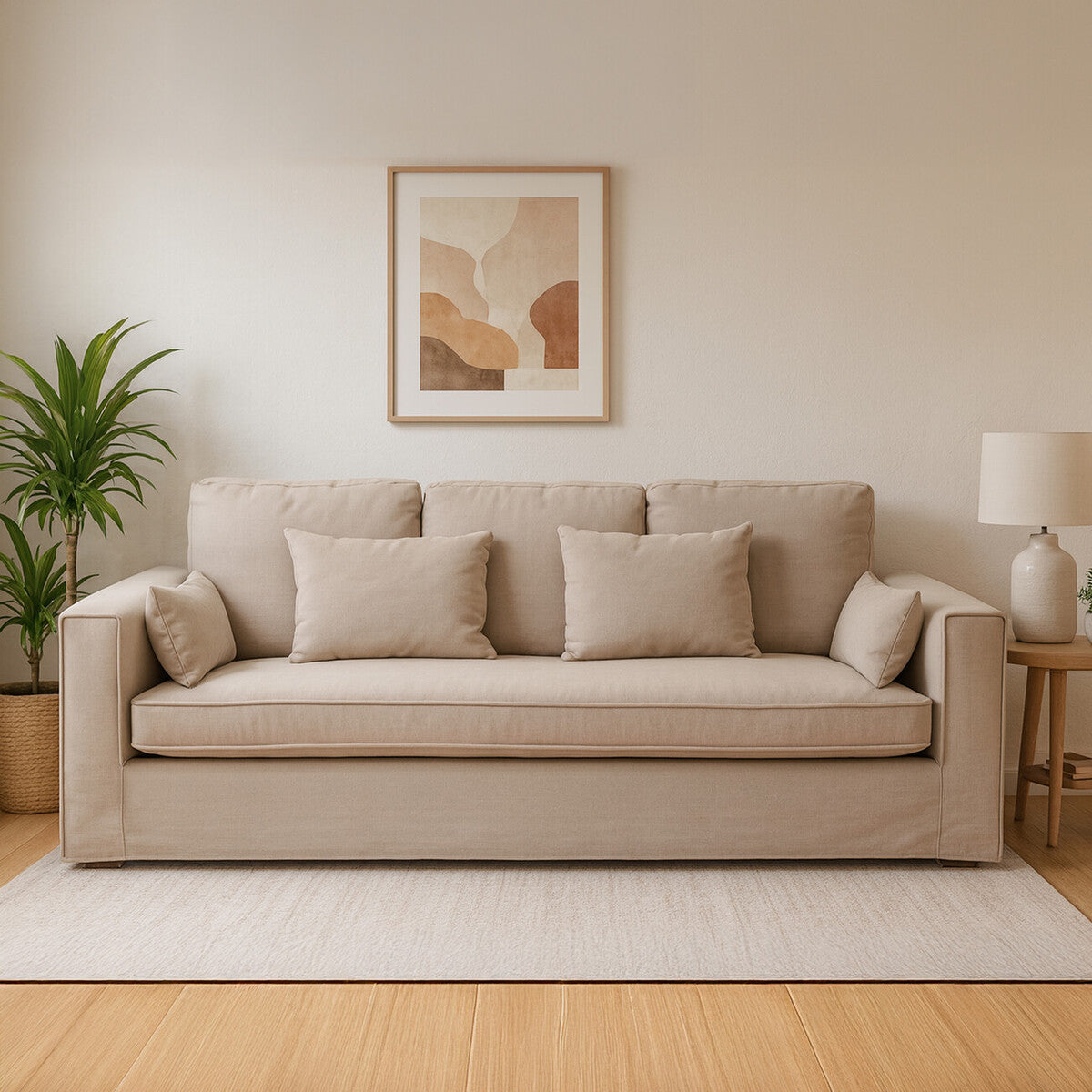 Beige sofa in a living room with a plant and abstract art on the wall.