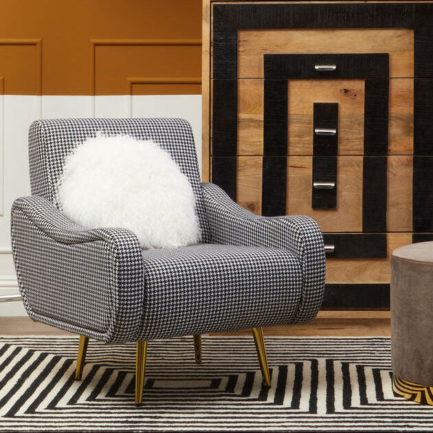 Modern interior with a gray armchair, wooden sideboard, and decorative items.