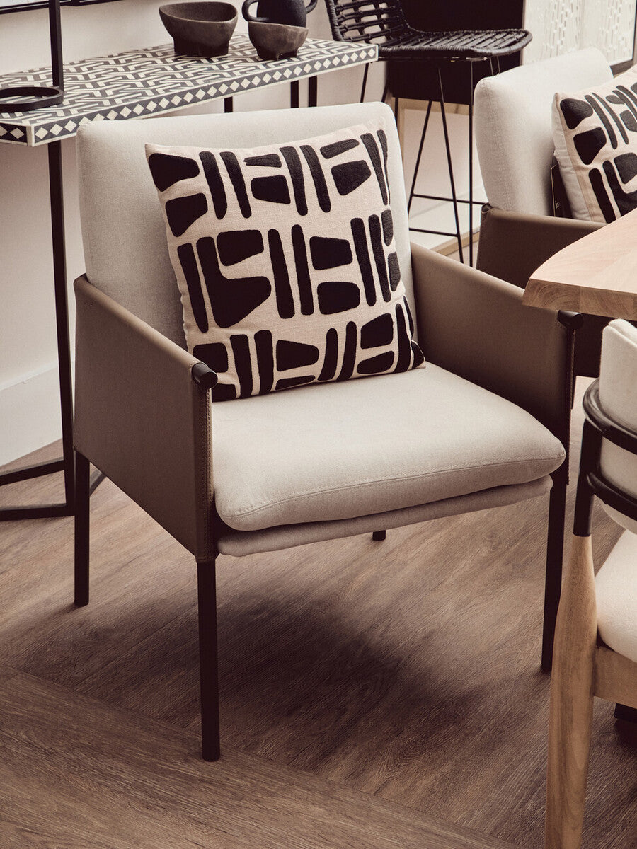 Chair with a patterned pillow in a modern indoor setting
