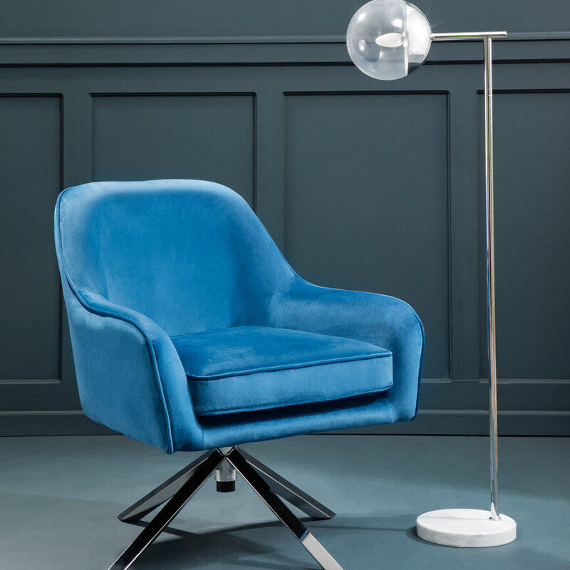 Blue armchair with a modern floor lamp against a dark wall.