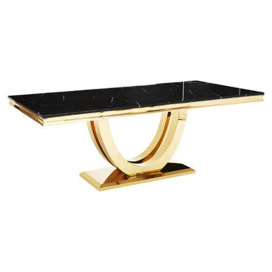 Dining table with black marble top and gold metal base on a white background