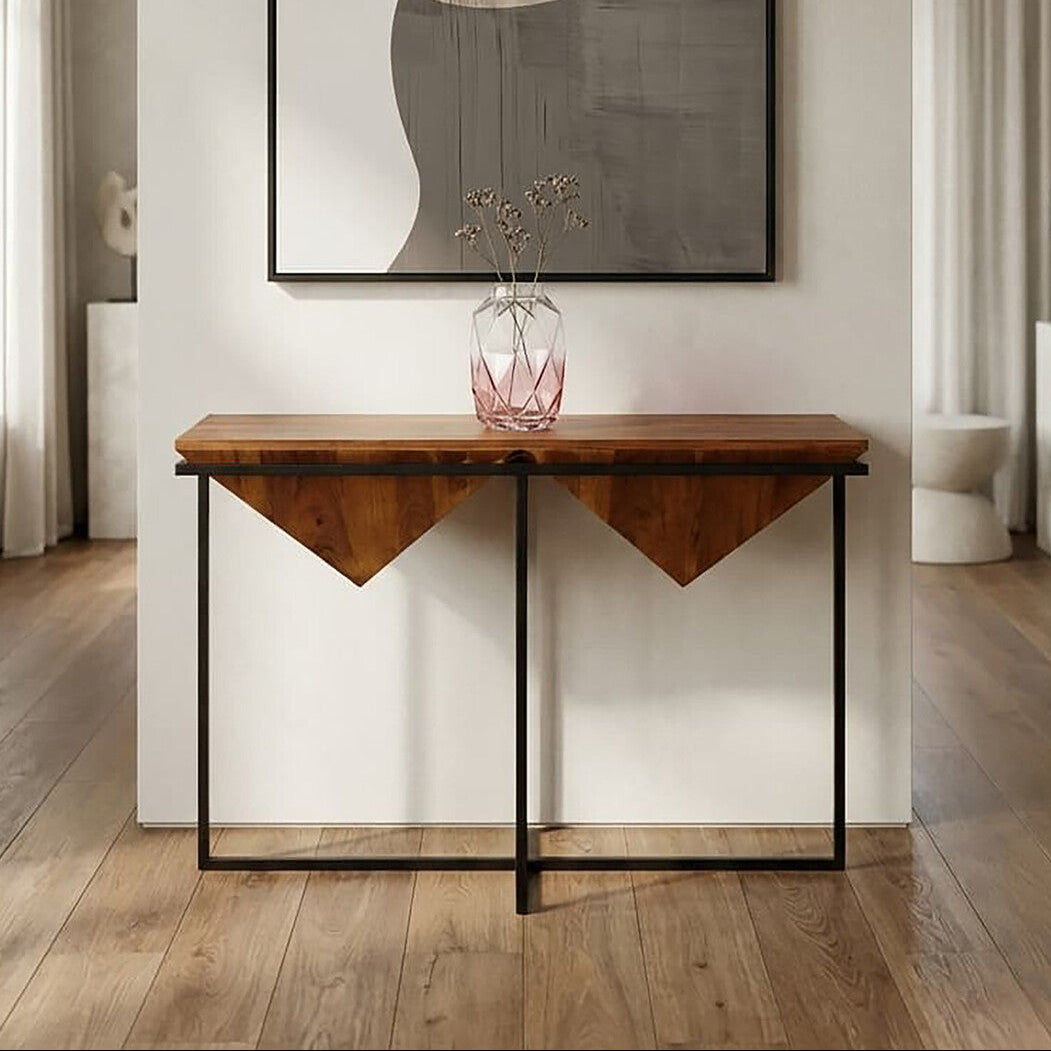 Wooden console table with a vase on top in a room with abstract art on the wall.