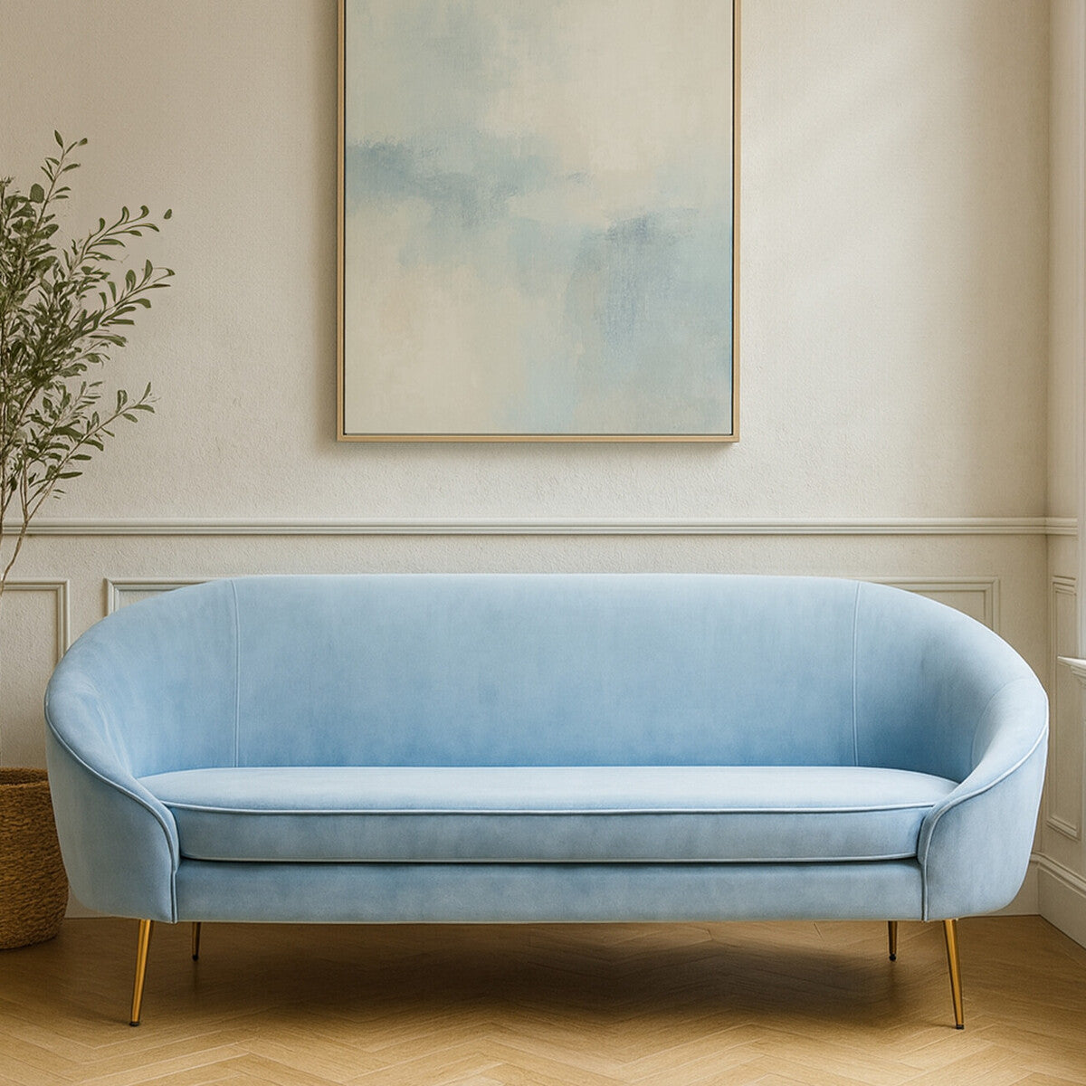Light blue sofa in a room with a painting and plant