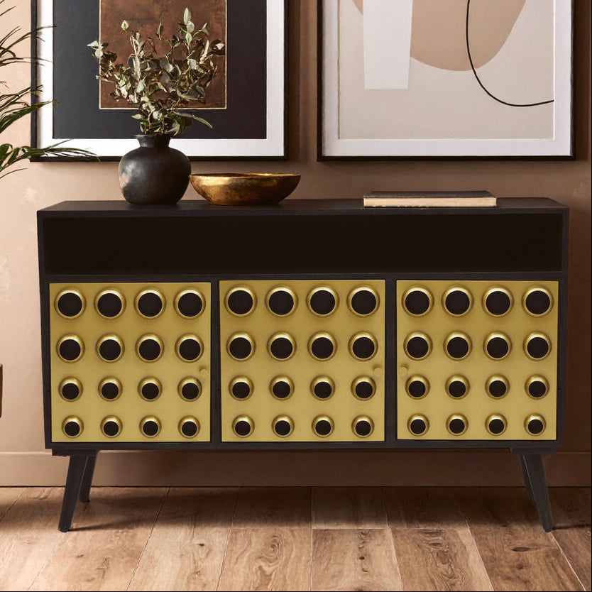 Modern console table with decorative items against a wall with abstract art