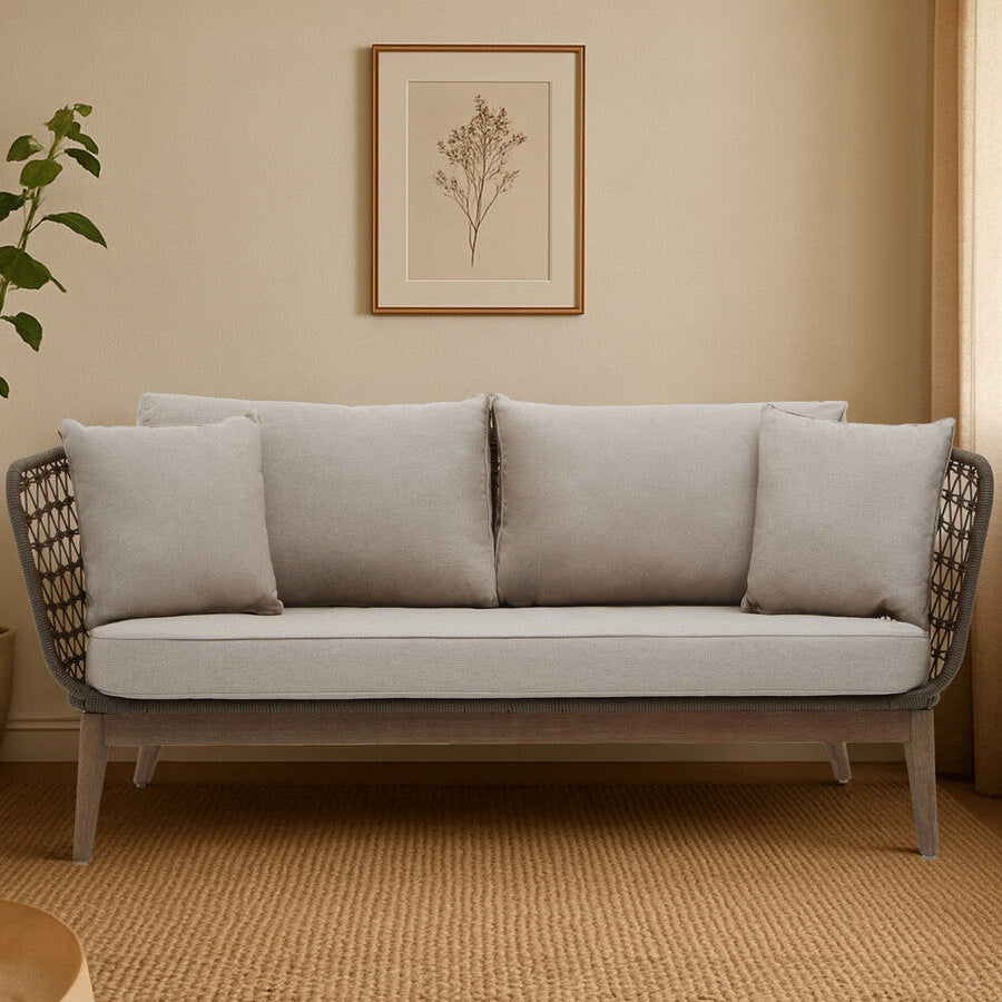 Gray sofa in a room with a framed picture on the wall and a plant.