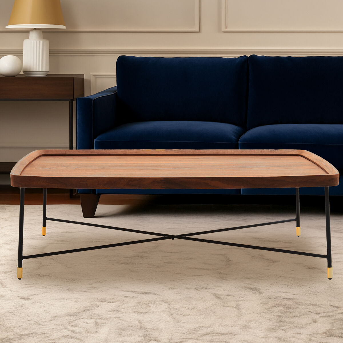 Wooden coffee table with black metal legs in front of a blue sofa in a living room.