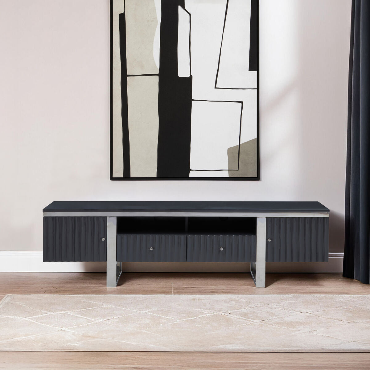 Modern black entertainment console against a white wall with abstract art above it.