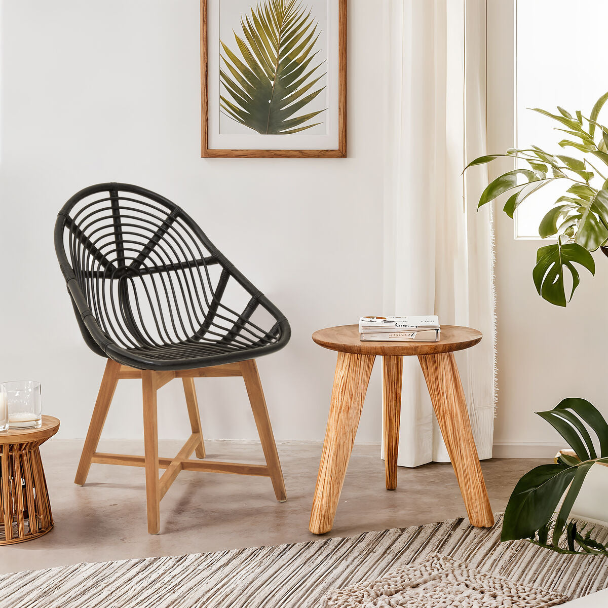 Black woven chair and wooden side table in a room with plants and framed artwork.